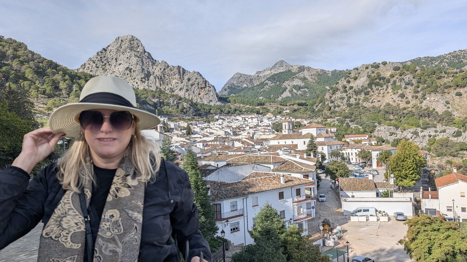 Grazalema is situated in a mountain bowl.  It's very windy there -- hence holding the hat